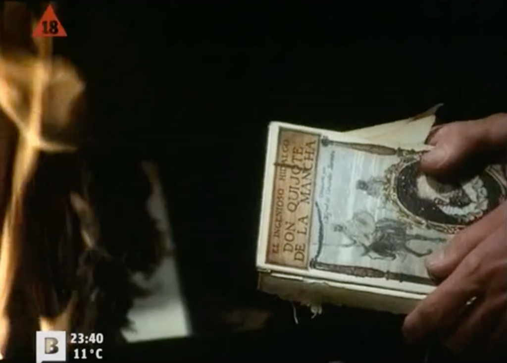 Photogramme tiré du film Tatuaje.
On voit les mains d'un homme en train de jeter dans un feu le livre Don Quijote de la Mancha.