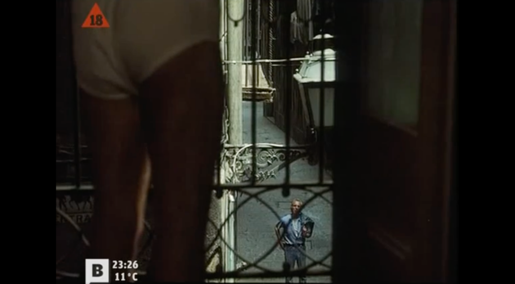 Photogramme tiré du film Tatuaje.
On voit un homme de dos en slip devant une fenêtre. Par cette fenêtre, on peut voir un autre homme.